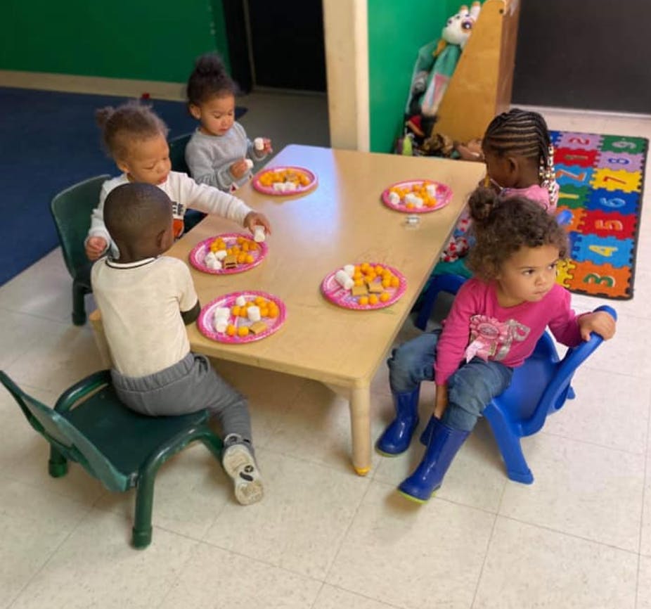 Children sitting at a table with plates of food