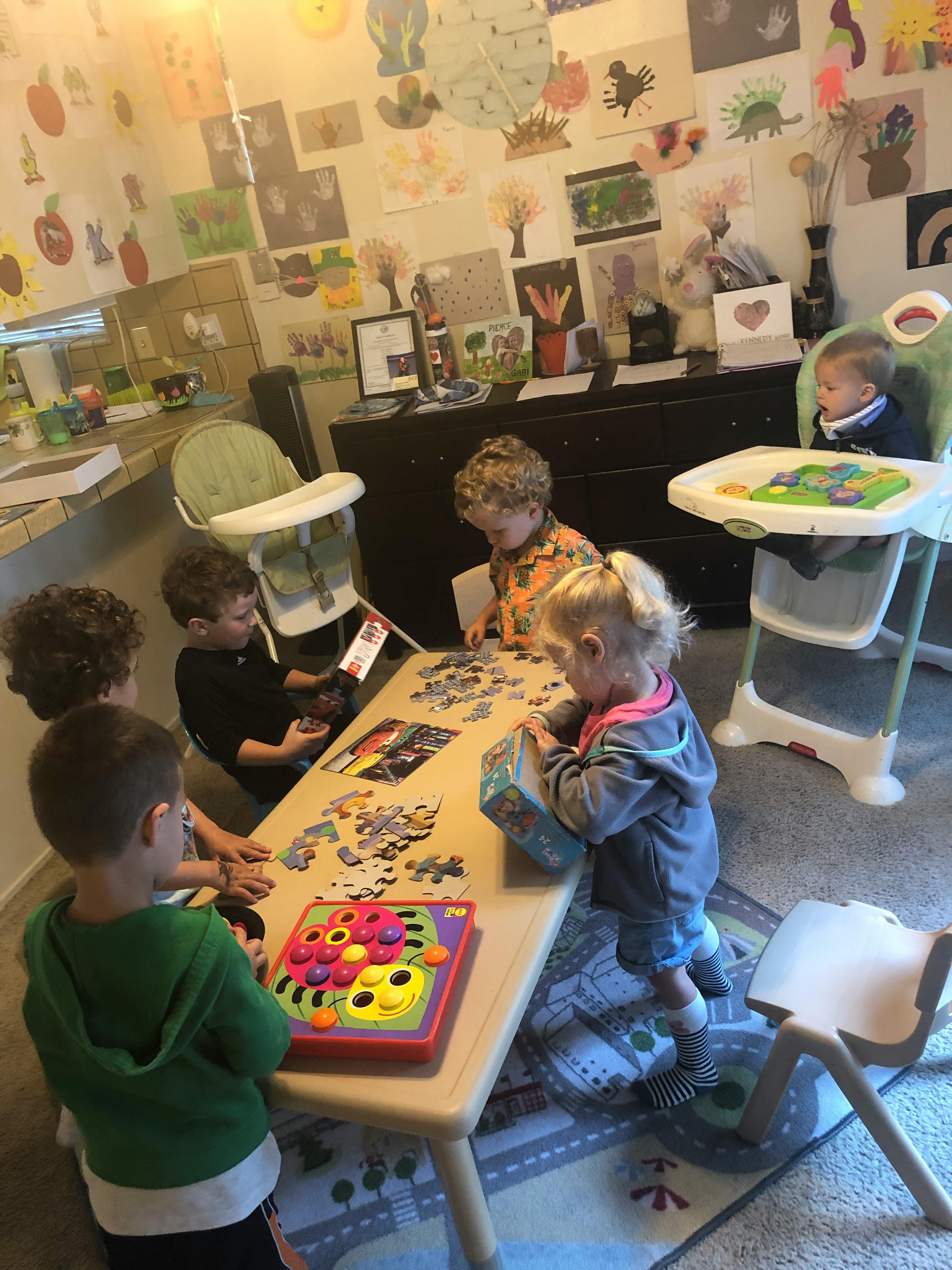 Children playing with puzzles and toys at a table
