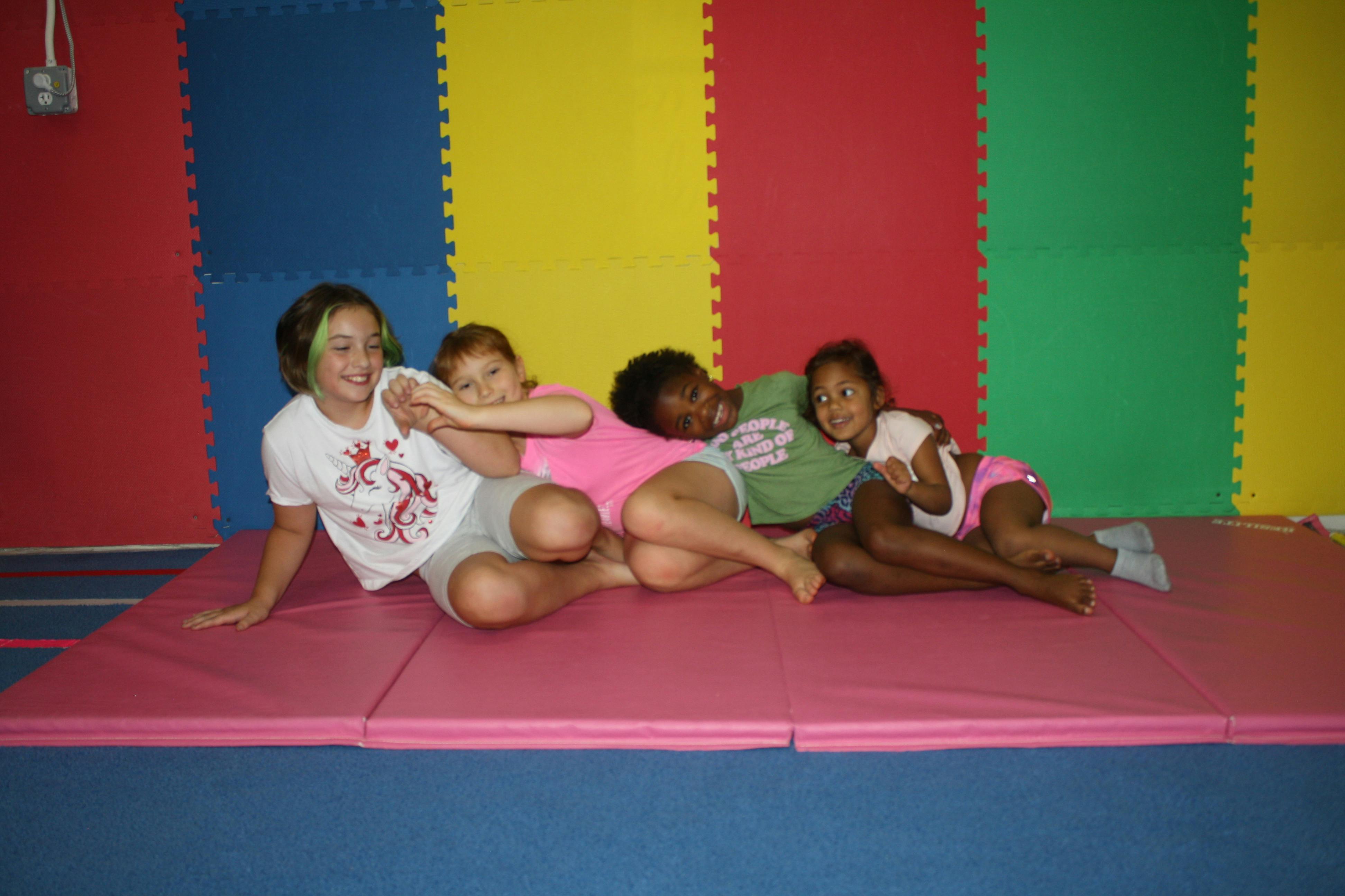 Four children lying on a mat