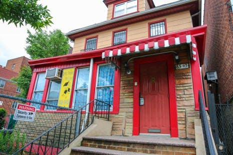 Front exterior of a house with red trim and a red door
