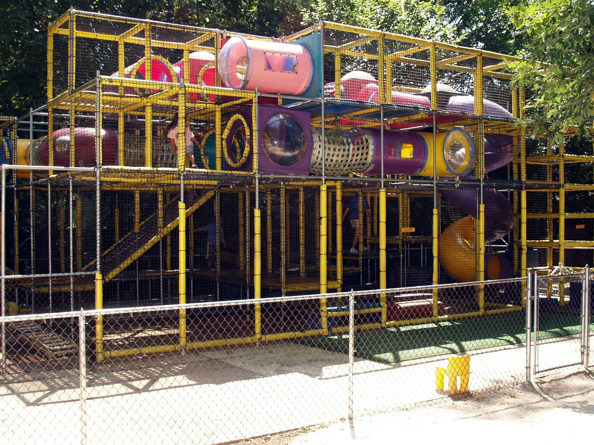 Large outdoor playground structure with multiple levels and tunnels