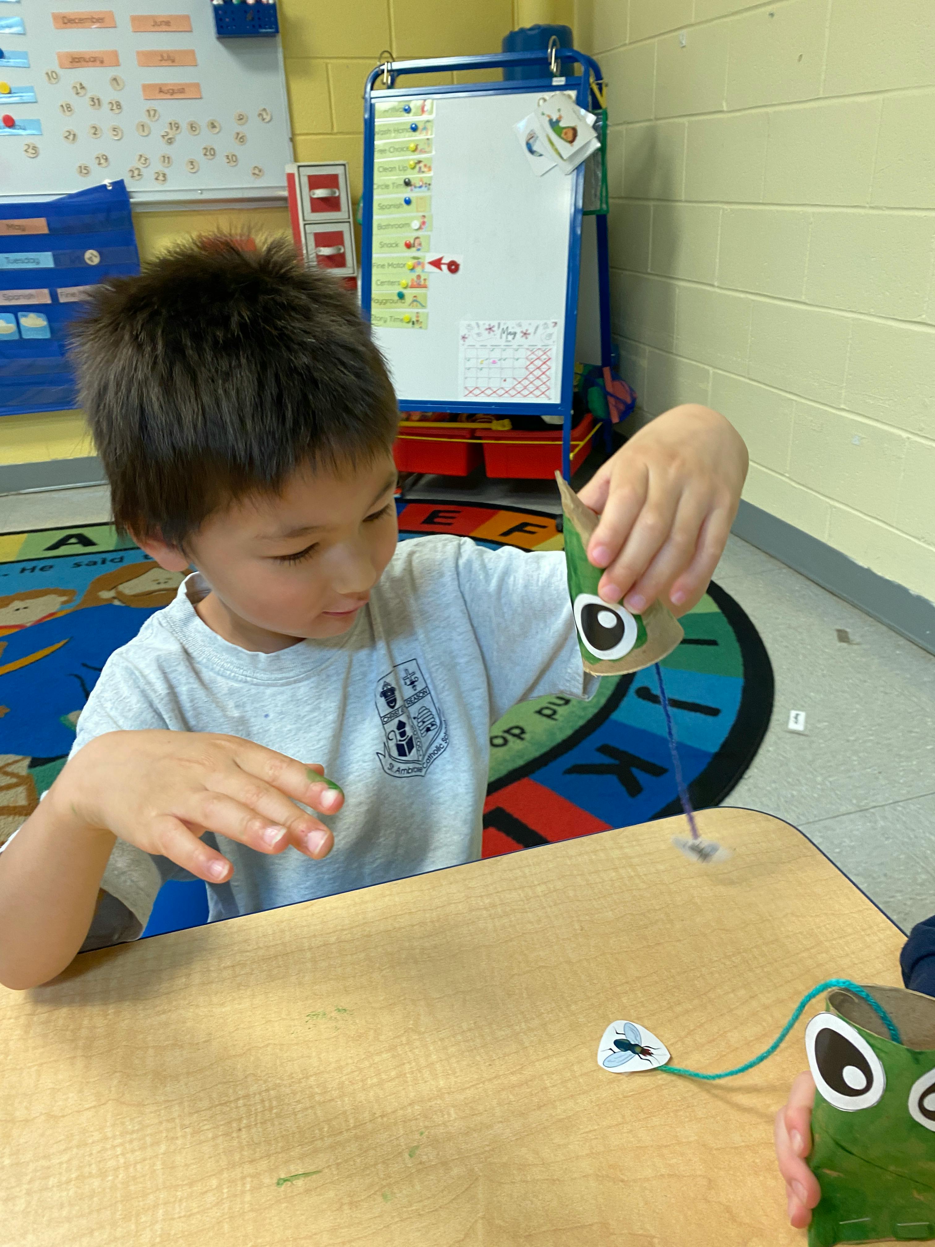 Child playing with a craft toy at a table