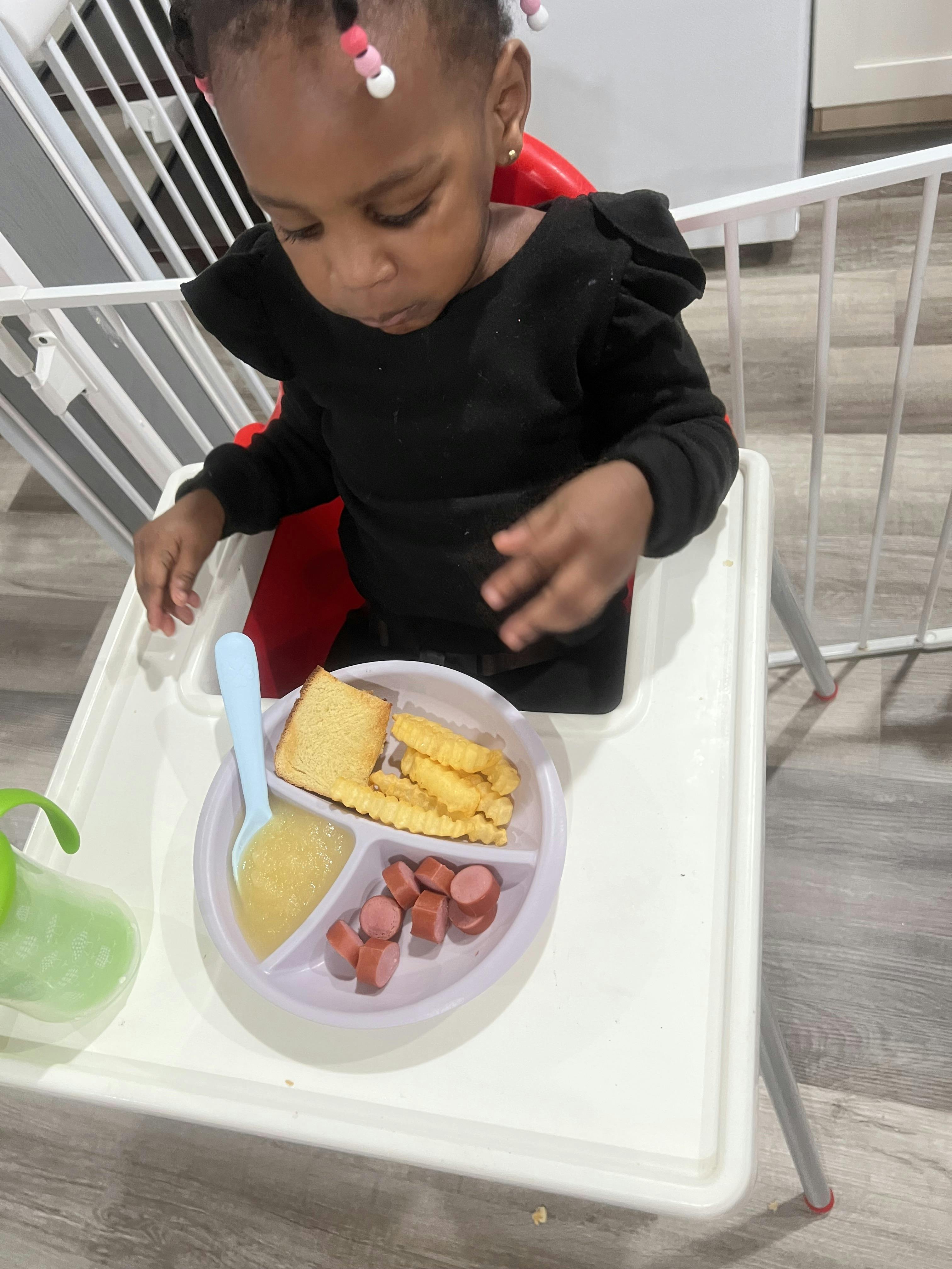 Child in a high chair with a plate of food