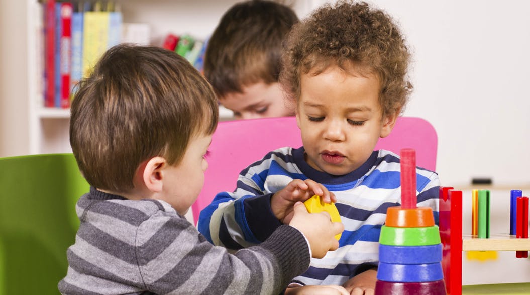 Two children playing with toys at a table