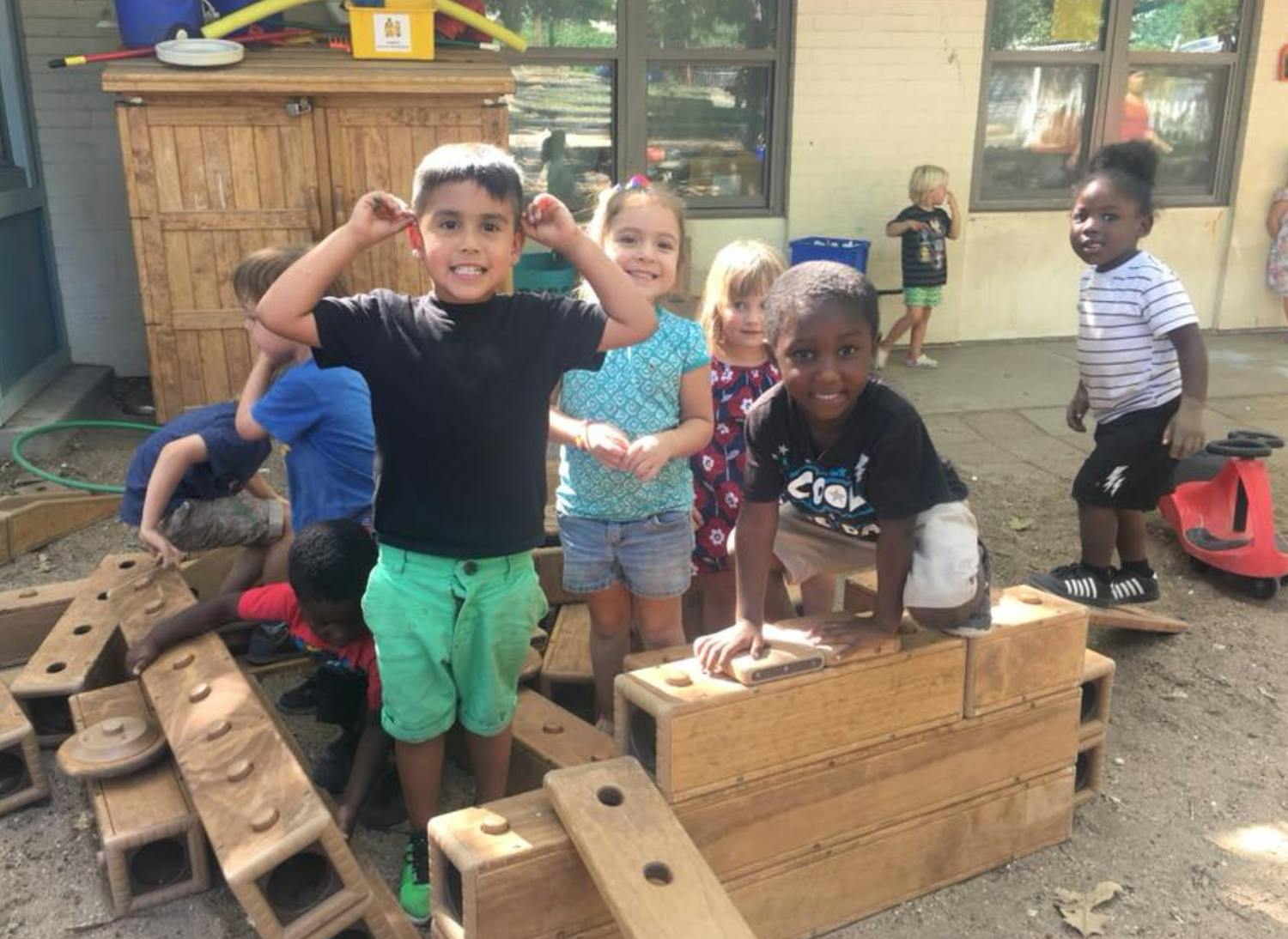 Children playing with wooden blocks outdoors