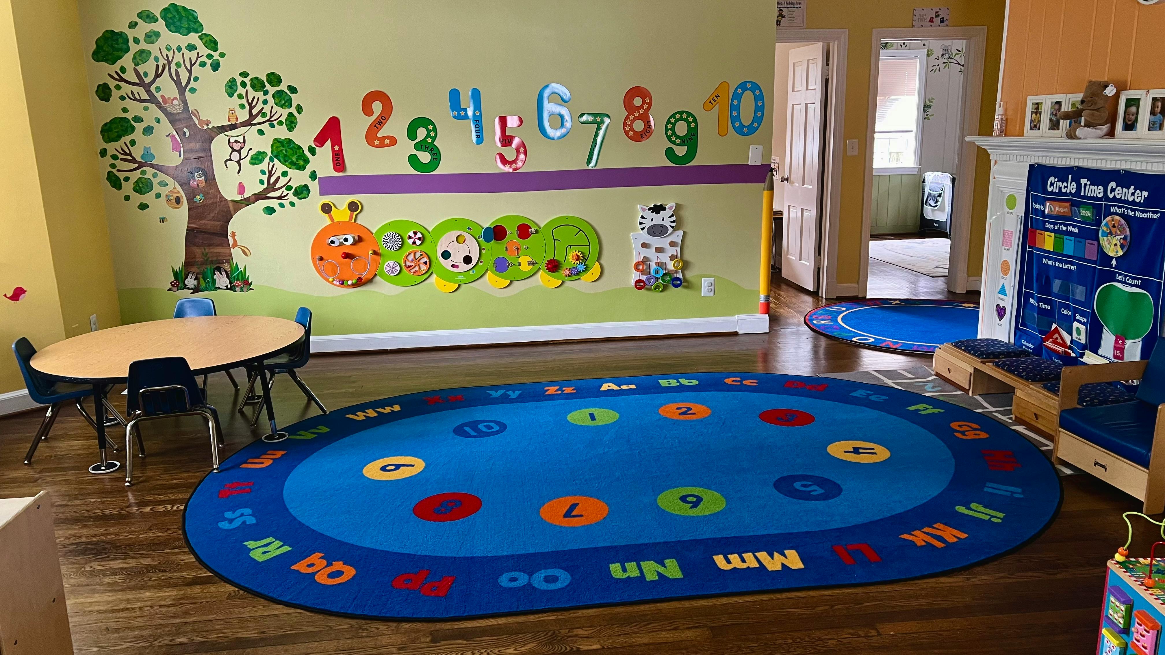 Child's classroom with a blue rug, small table, and wall decorations