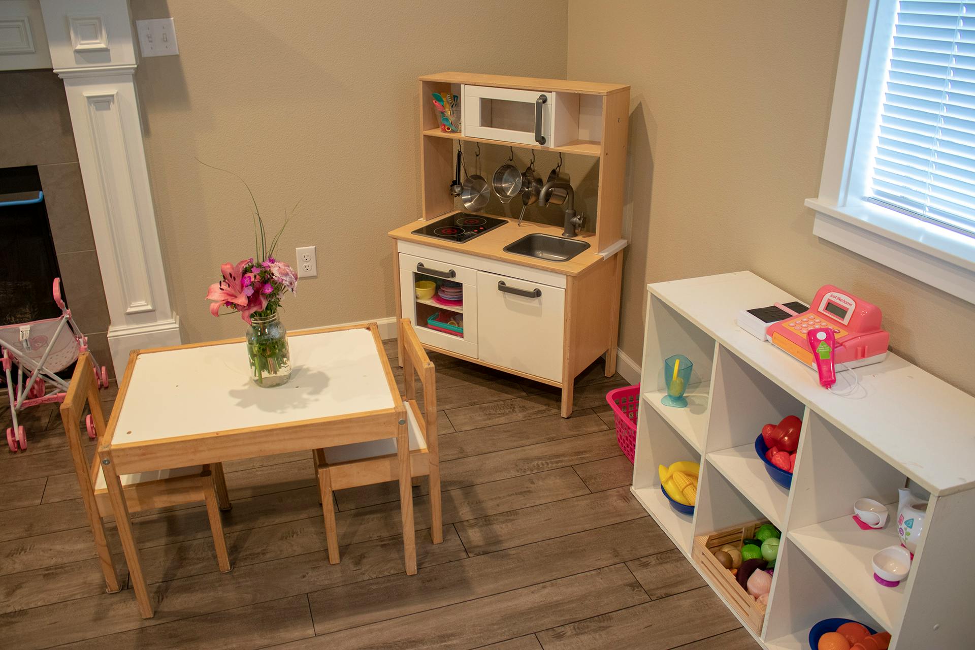 Play kitchen and small table with chairs in a room