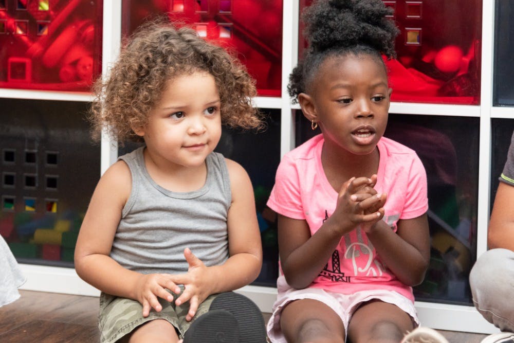 Two children sitting, one speaking