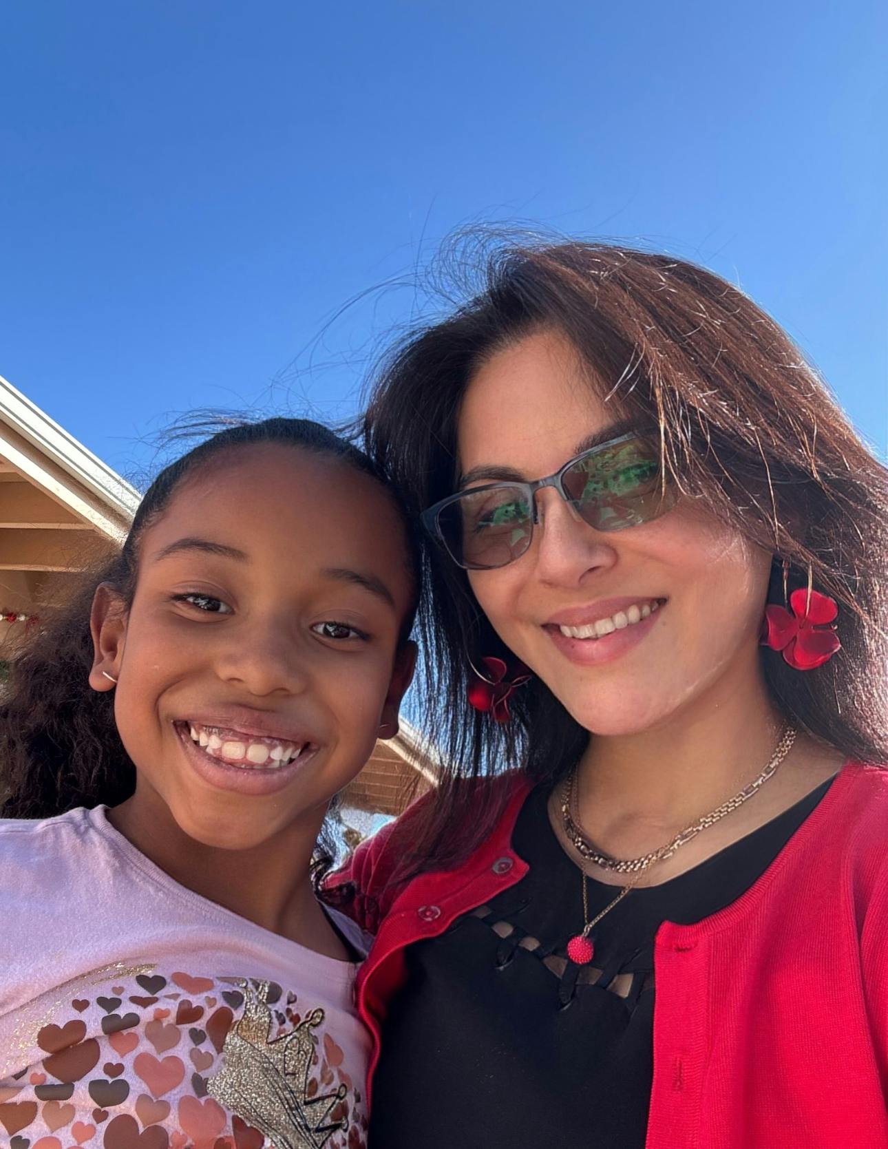 A person and a child smiling together outdoors