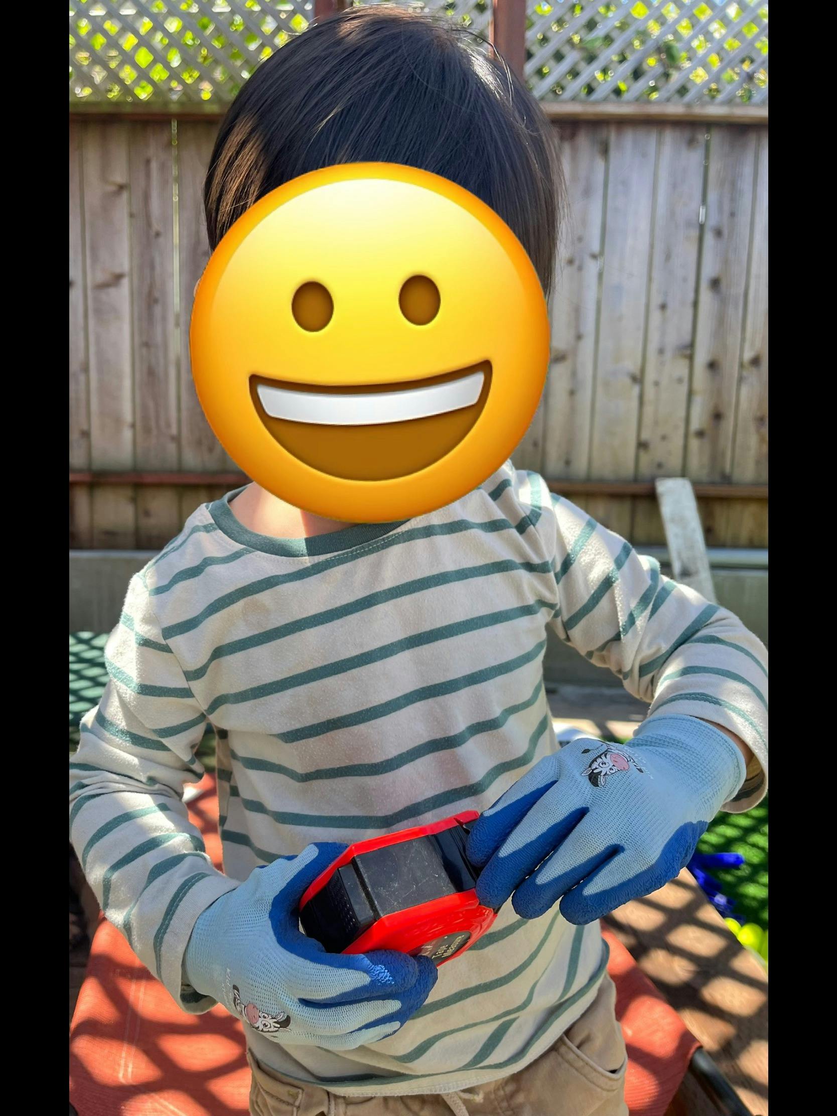 Child wearing gloves and holding a toy car