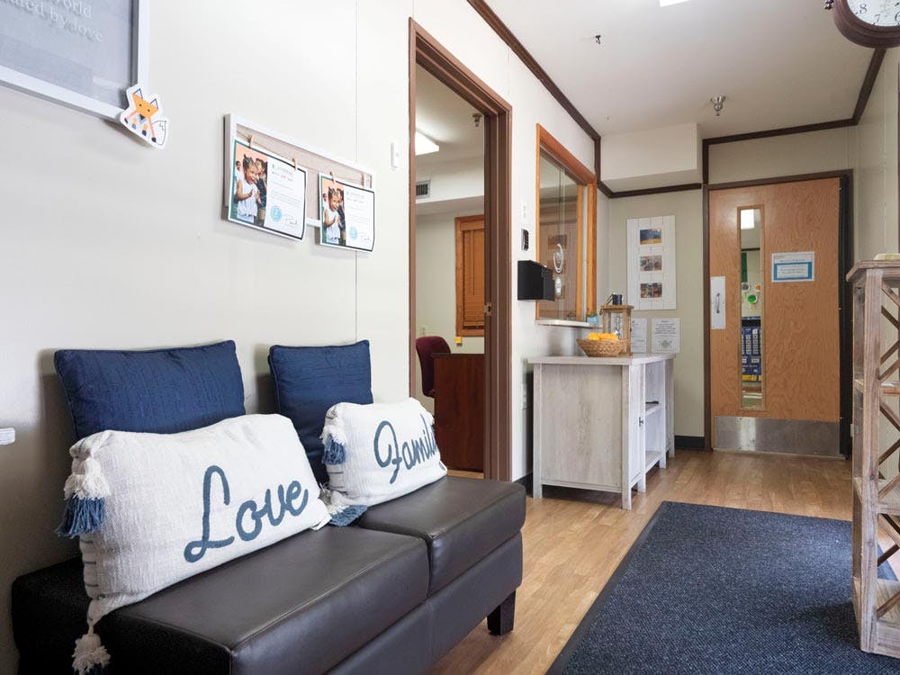 Lobby area with black seating, decorative pillows, and wooden doors