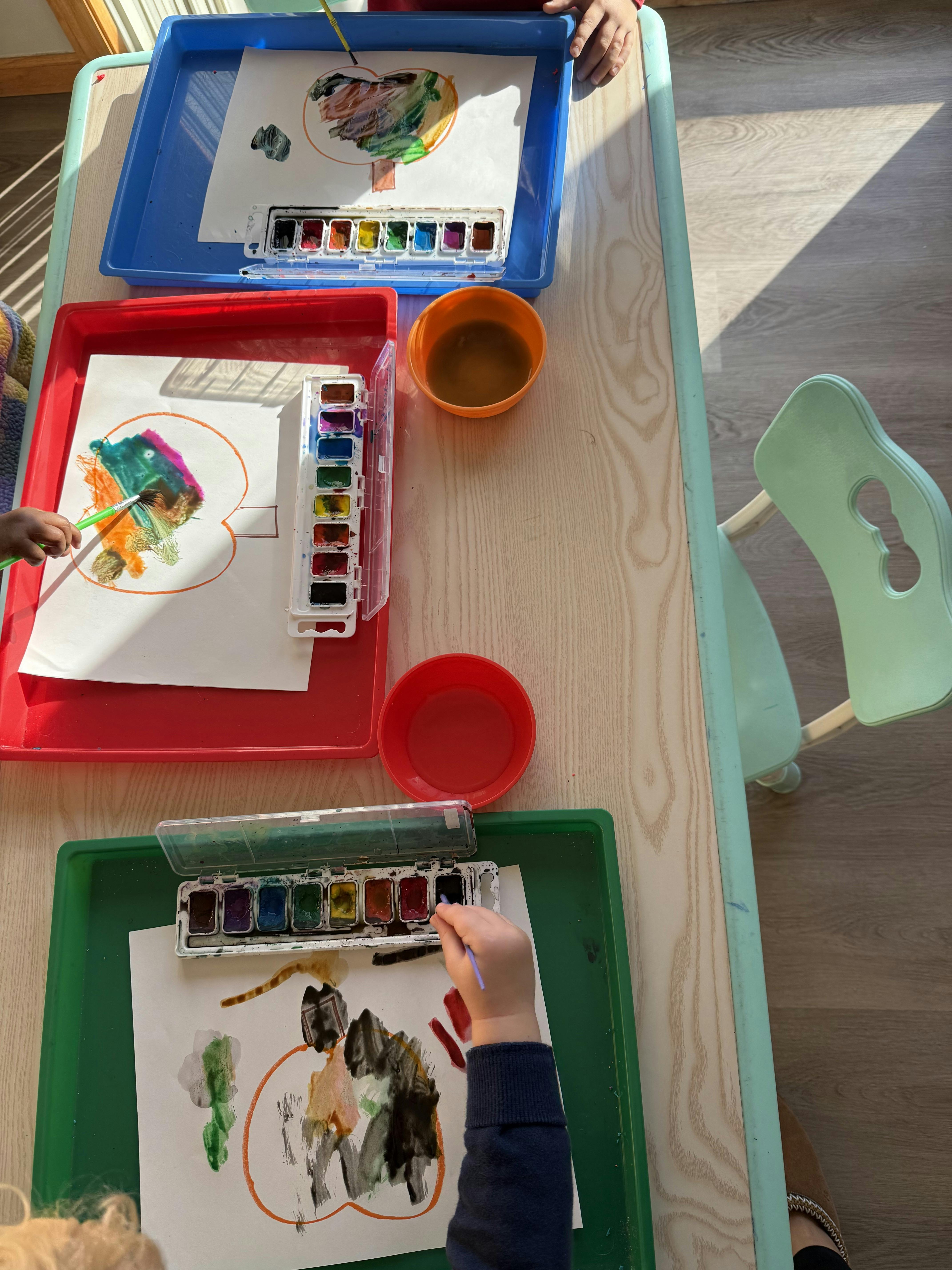 Children painting with watercolors at a table