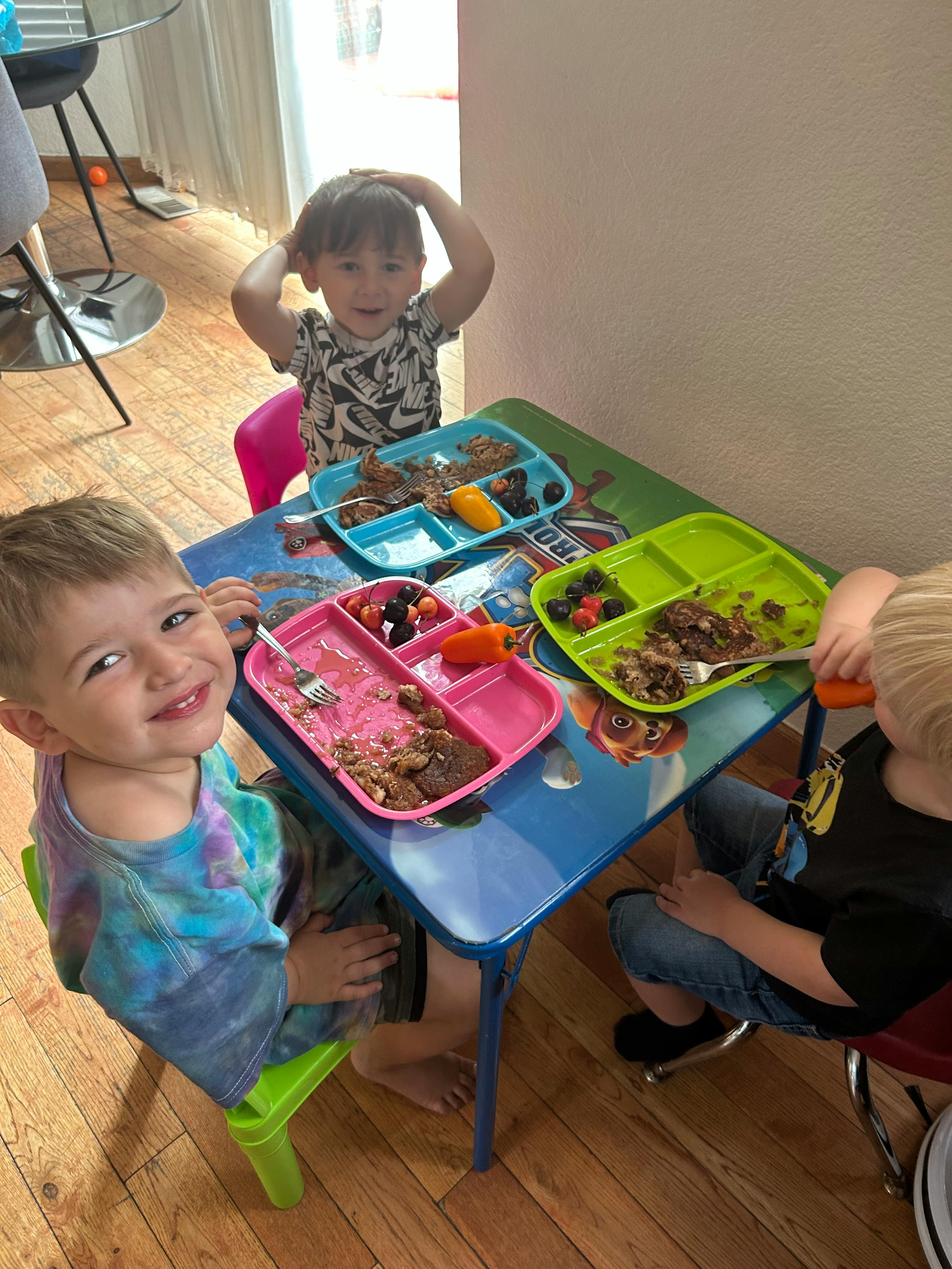 Three children eating at a small table