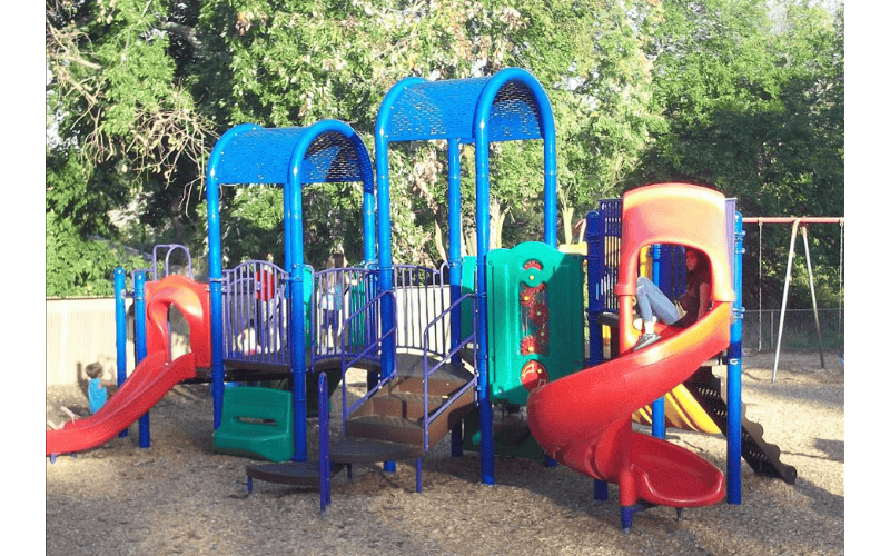 Children on a colorful playground with slides and climbing structures