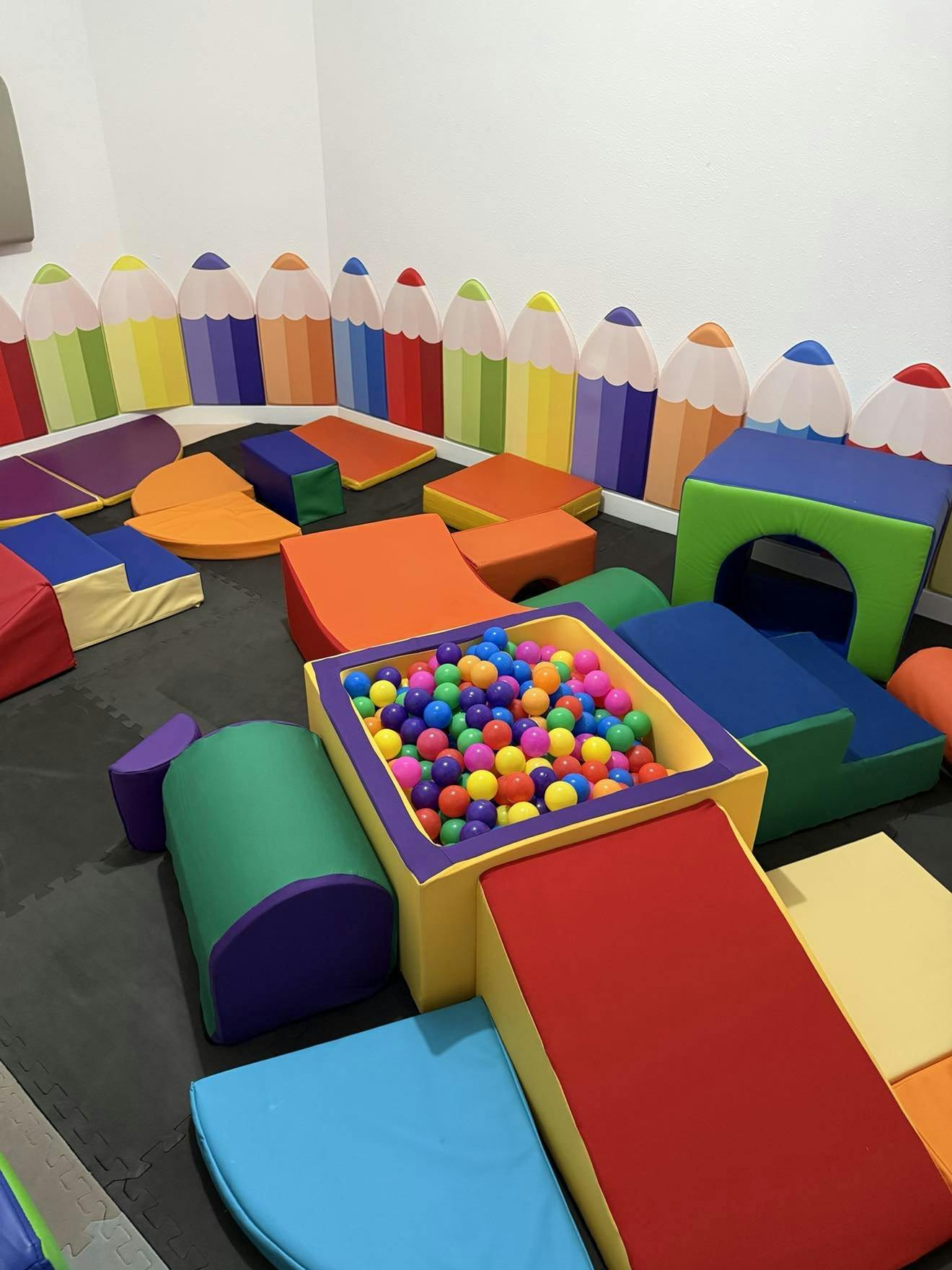 Indoor soft play area with colorful blocks and a ball pit