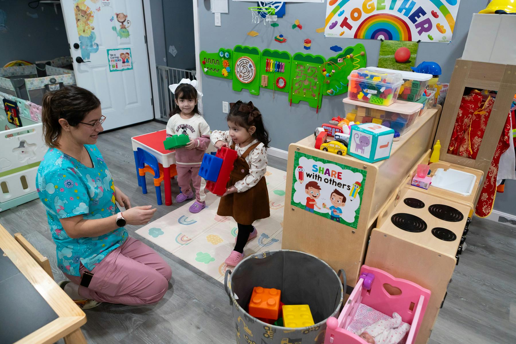 Adult and two children playing with blocks in a room