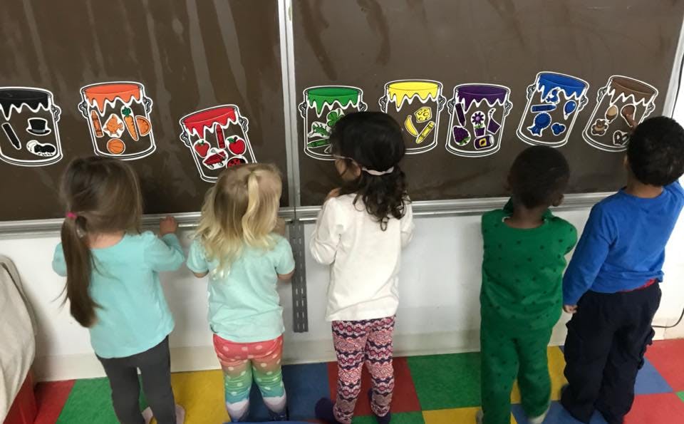 Children looking at colorful drawings on a wall