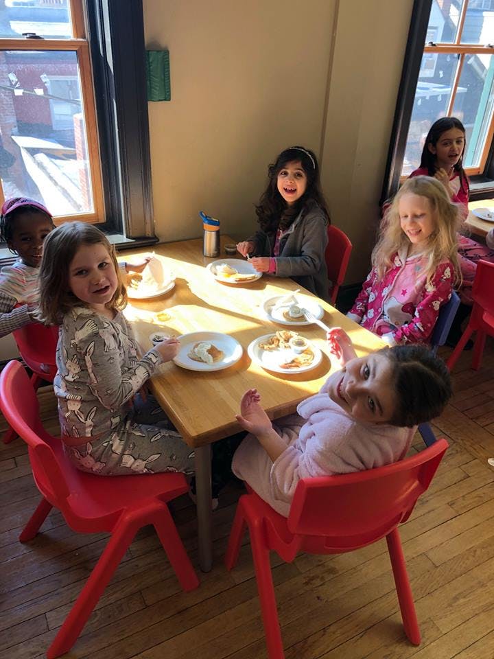 Children sitting at a table with plates of food