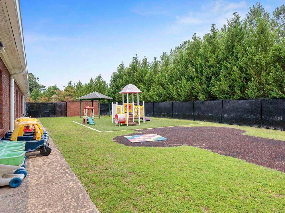 Playground area with climbing structures, slide, and a canopy tent
