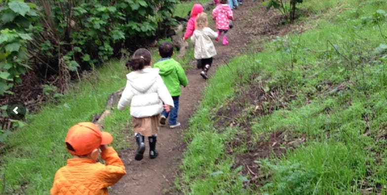 Children walking on a dirt path outdoors