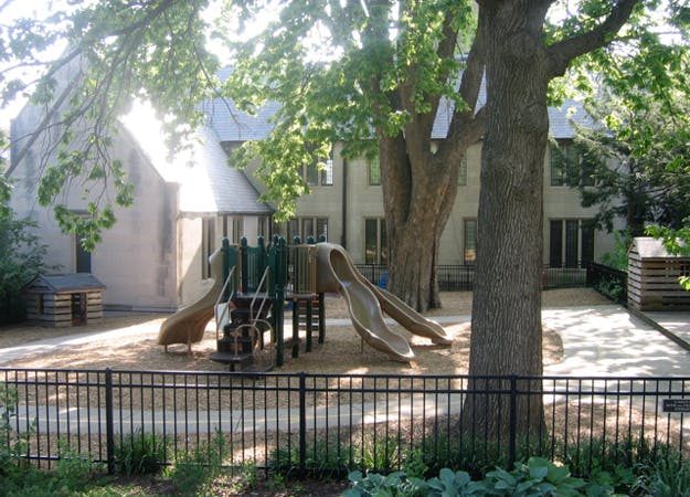 Playground with slides and climbing structure in front of a building