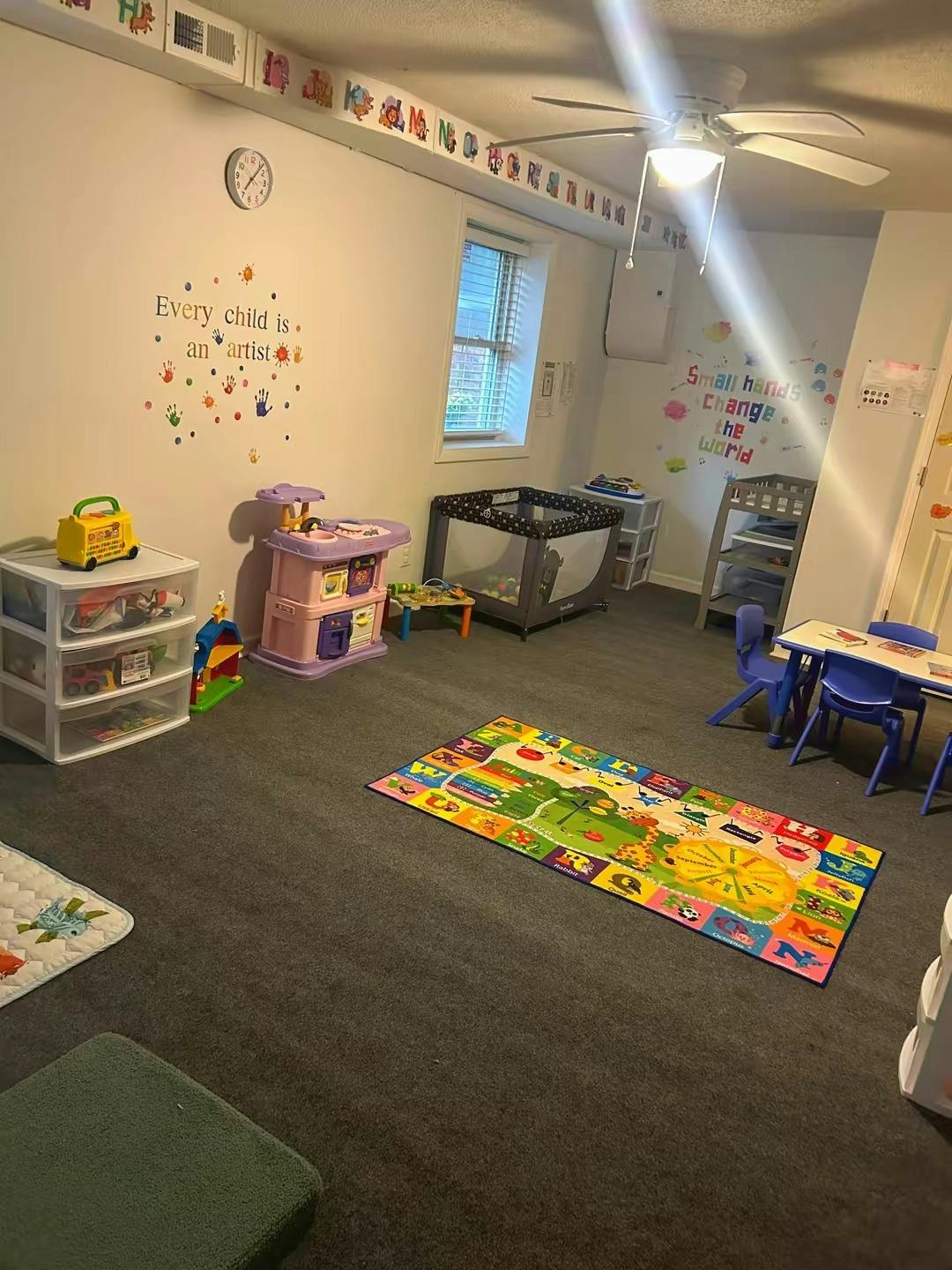 Child's playroom with toys, a crib, and a colorful rug on the floor