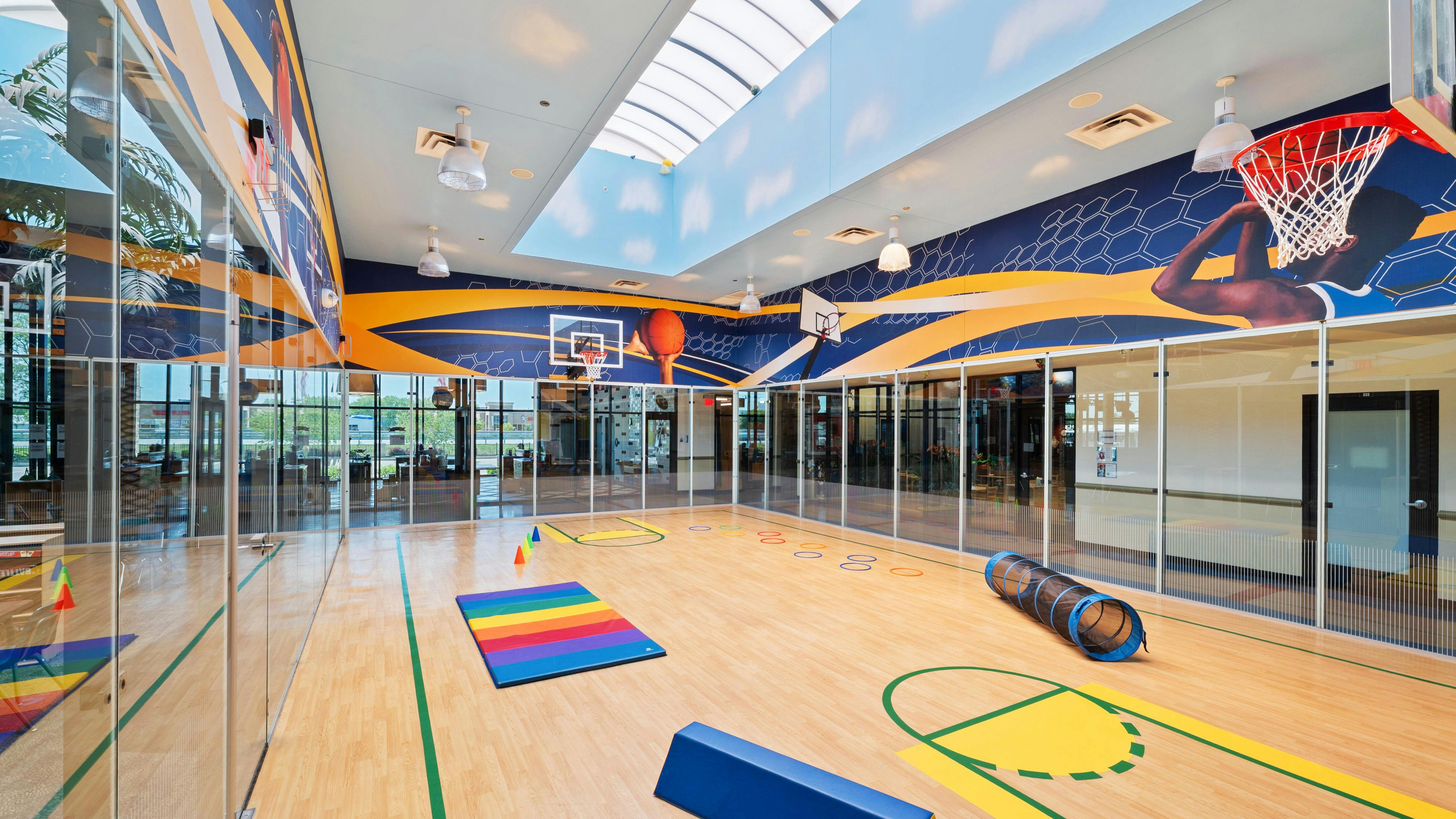 Indoor basketball court with colorful graphics and play equipment