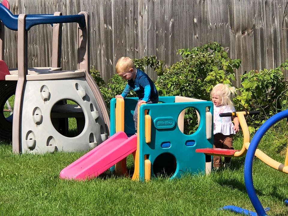 Two children playing on a colorful playground structure