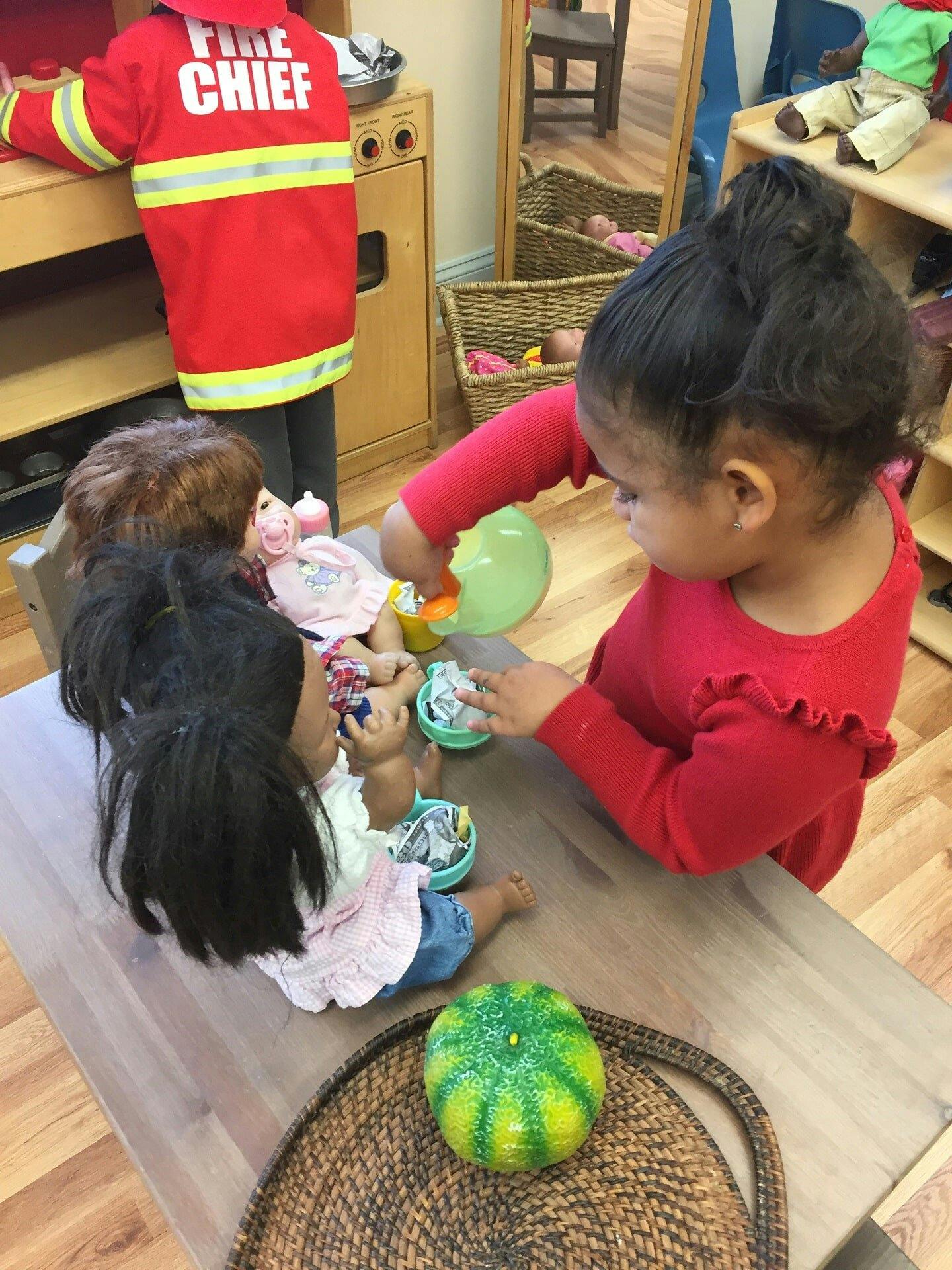 Child playing with dolls and toy food
