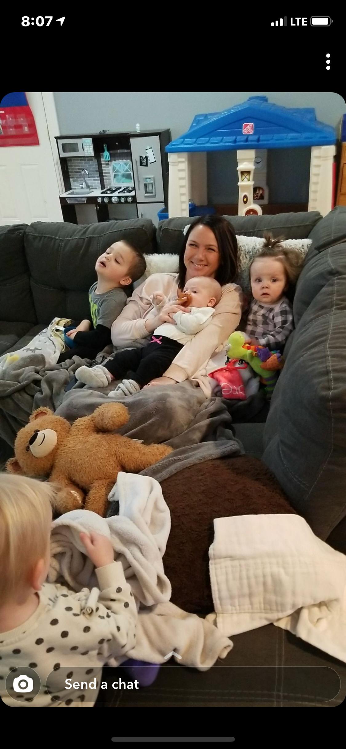 Person sitting on a couch with three children