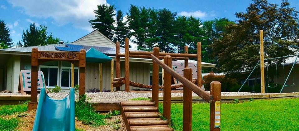 Playground with wooden structures, a blue slide, and swings