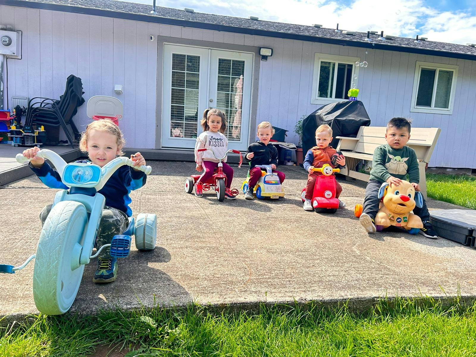 Children playing on ride-on toys outdoors