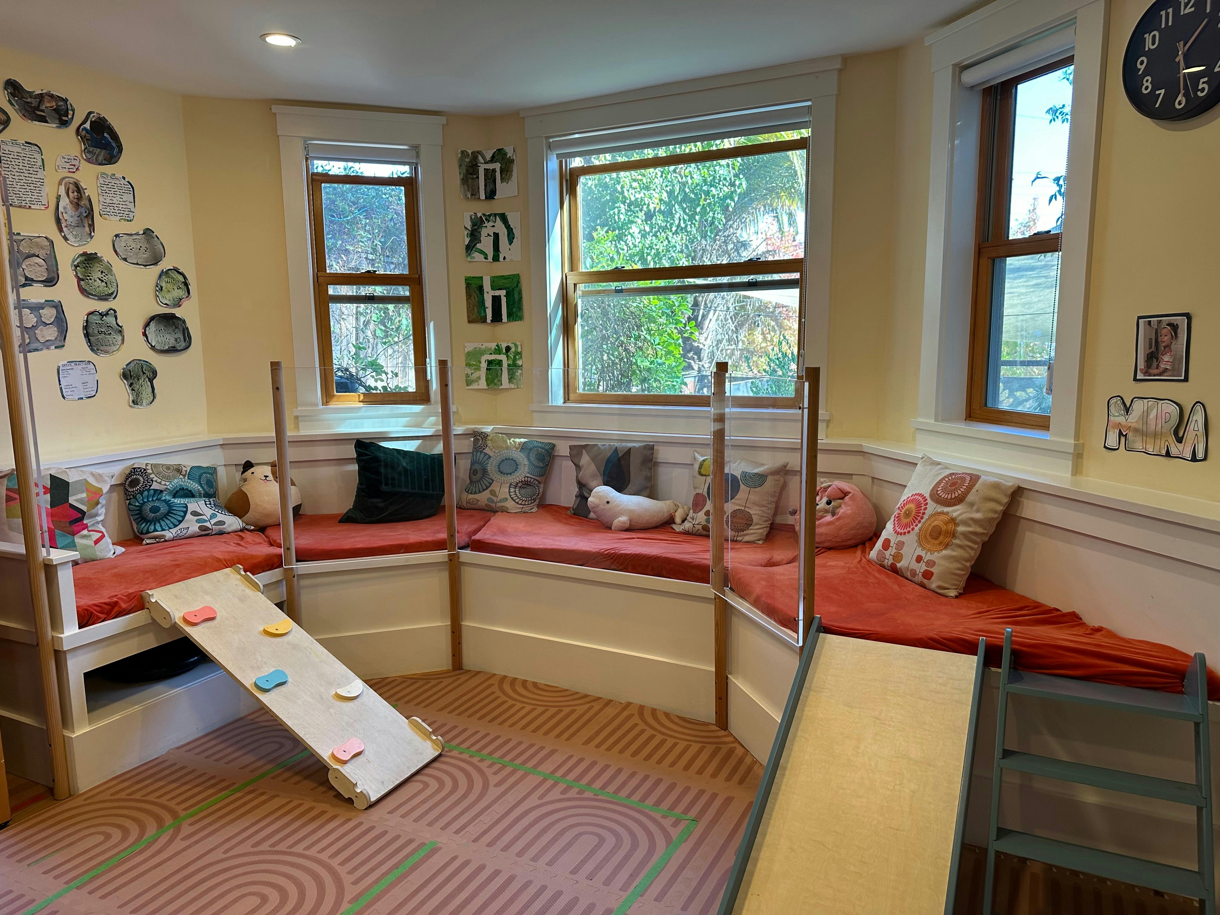 Playroom with window seats, cushions, and two slides