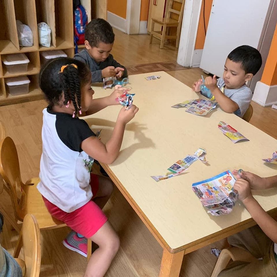 Children sitting at a table playing with cards