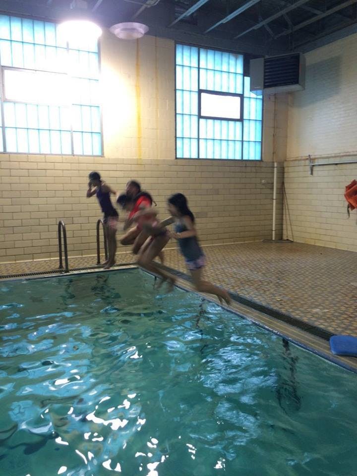 People jumping into a swimming pool