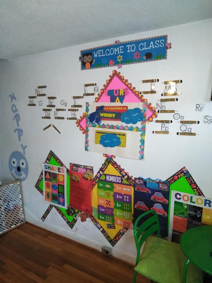 Classroom wall with educational posters including letters, shapes, numbers, and colors