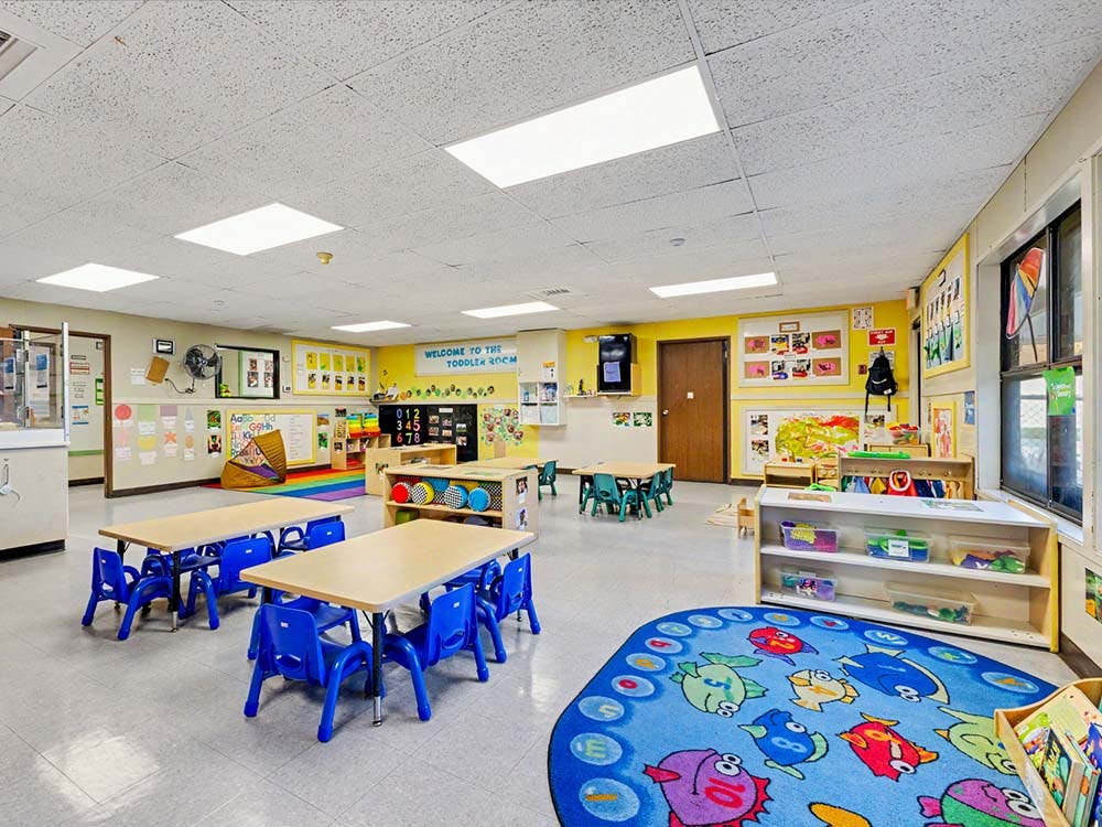 Colorful and bright toddler room with small tables and chairs