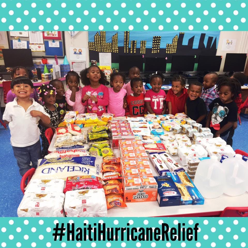 Group of children standing around a table filled with food and supplies