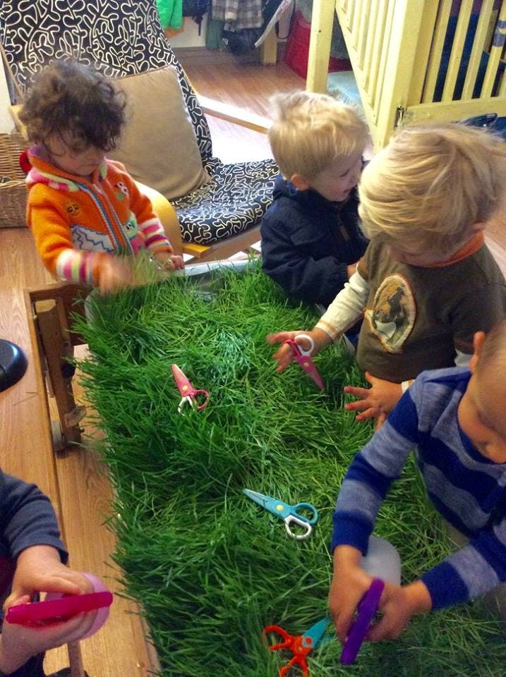 Children playing with scissors and grass