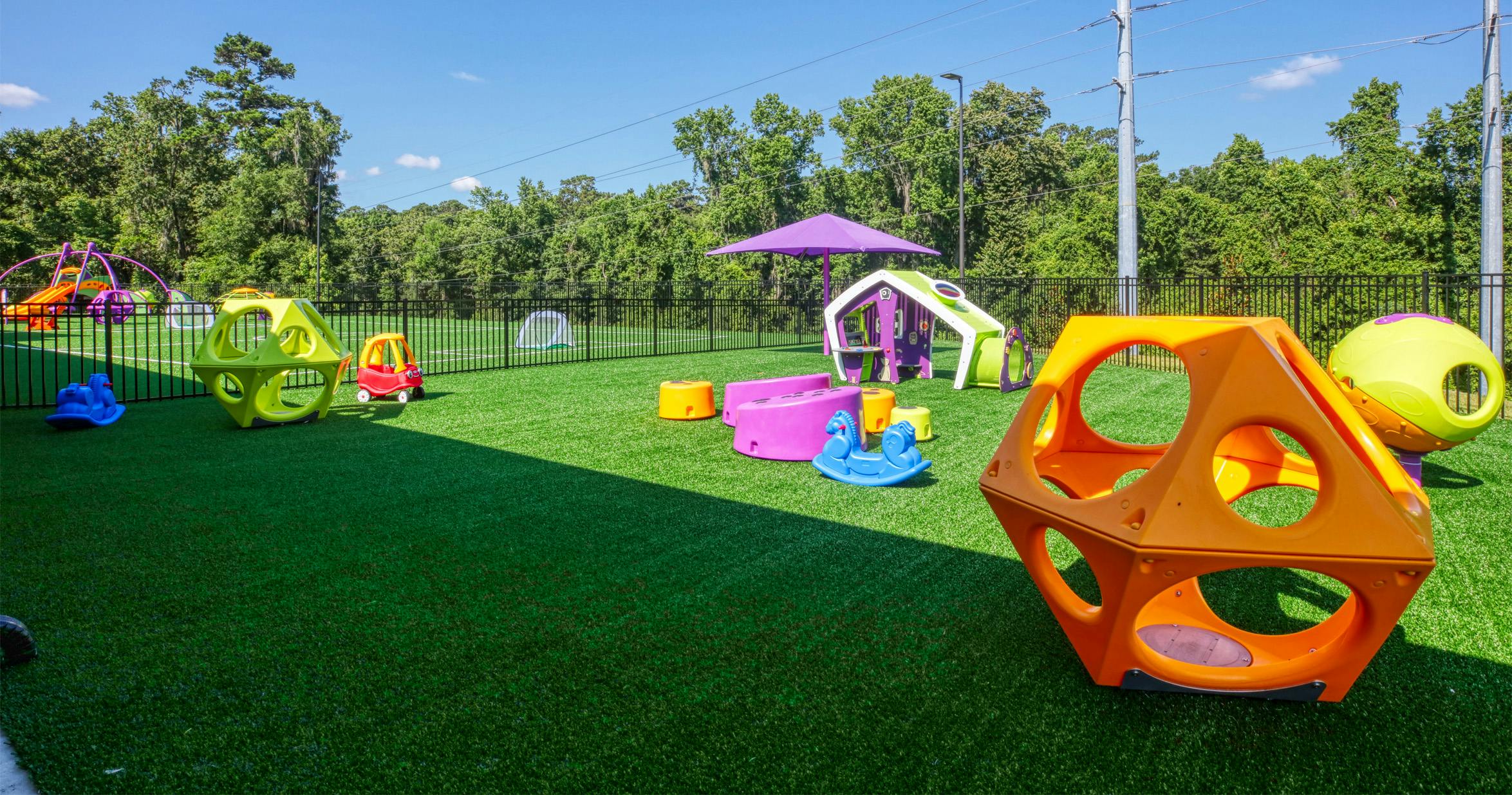 Playground with various colorful play structures on artificial turf
