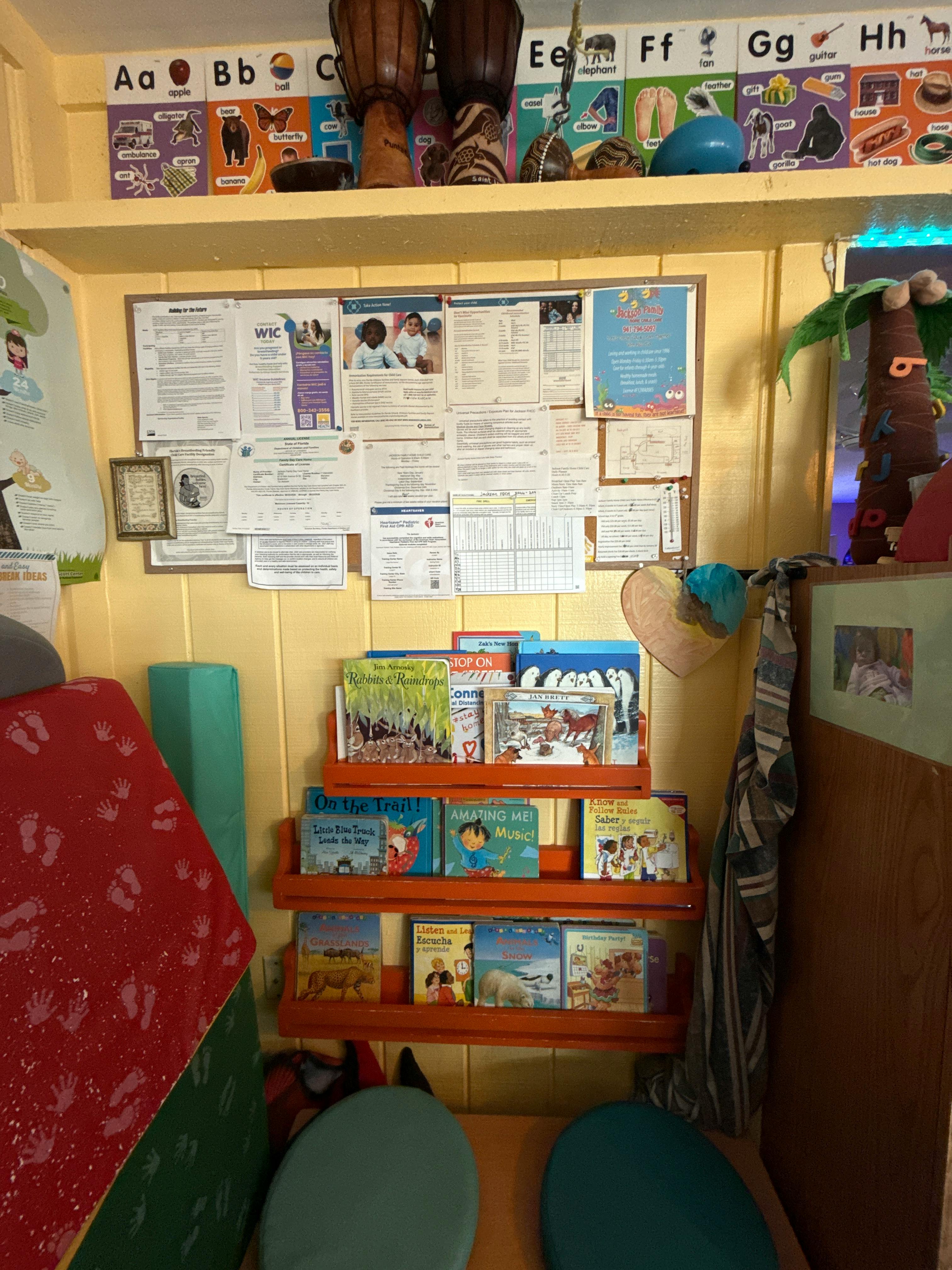 Classroom wall with a bulletin board displaying information and shelves of books