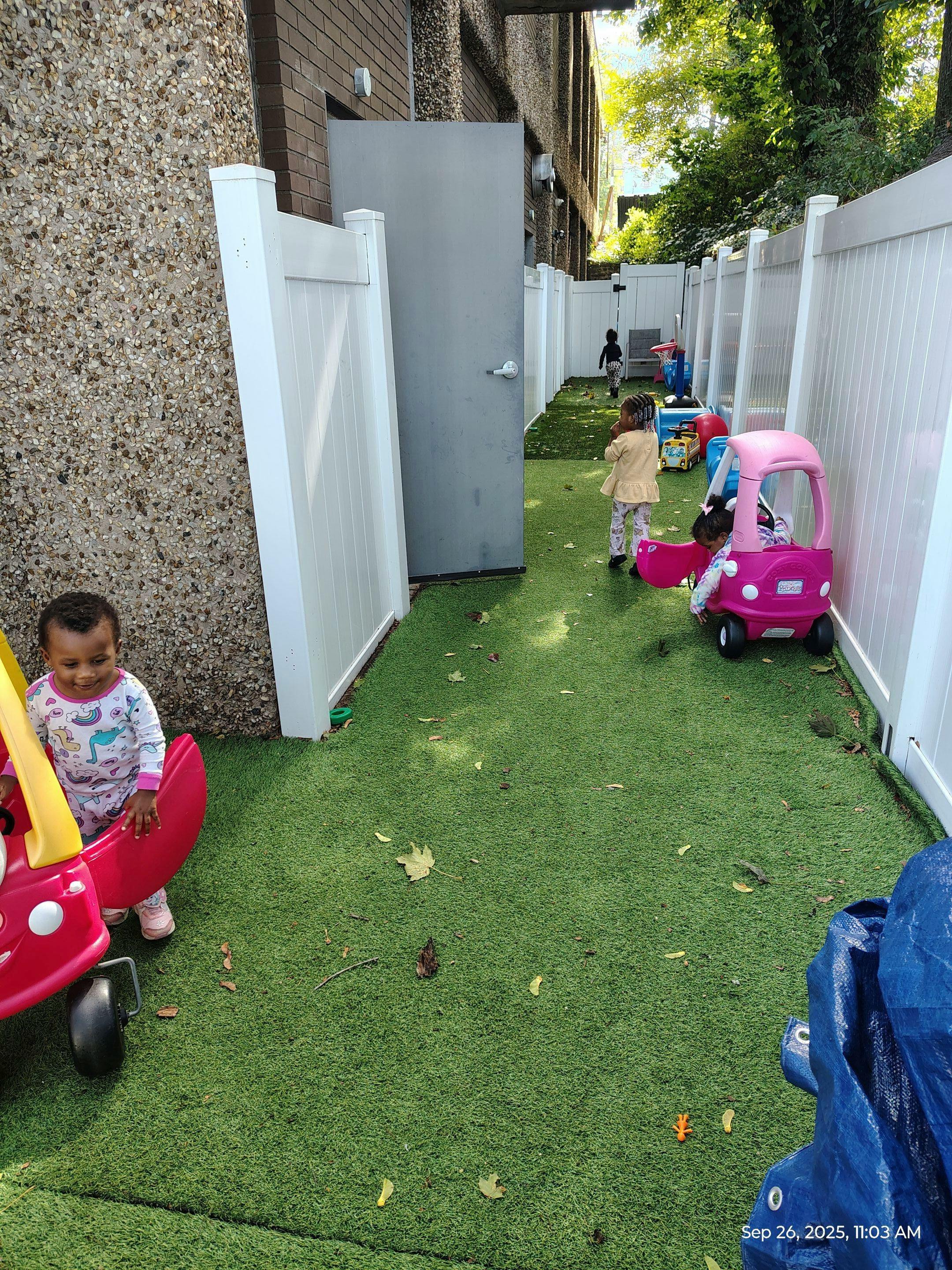 Children playing with toy cars on artificial grass outdoors