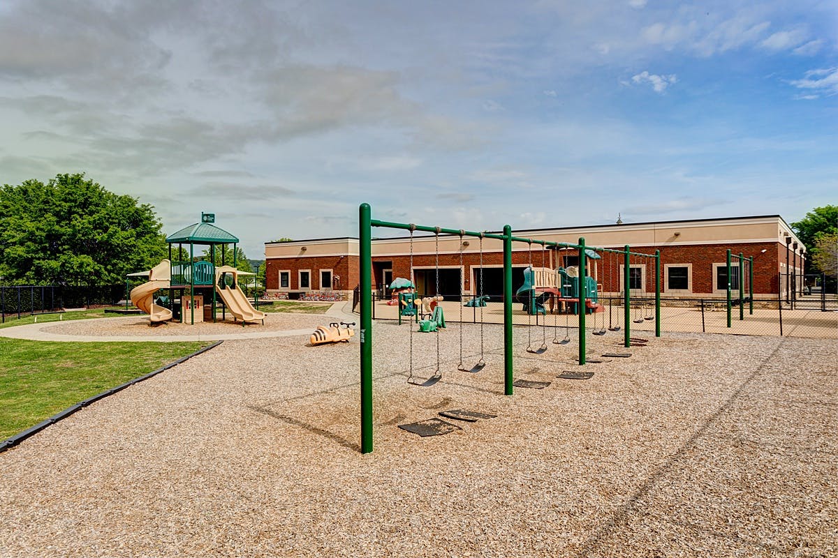 Playground with swings and slides in front of a building