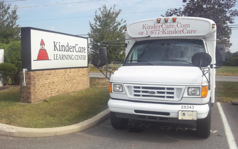 KinderCare Learning Center sign next to a KinderCare bus