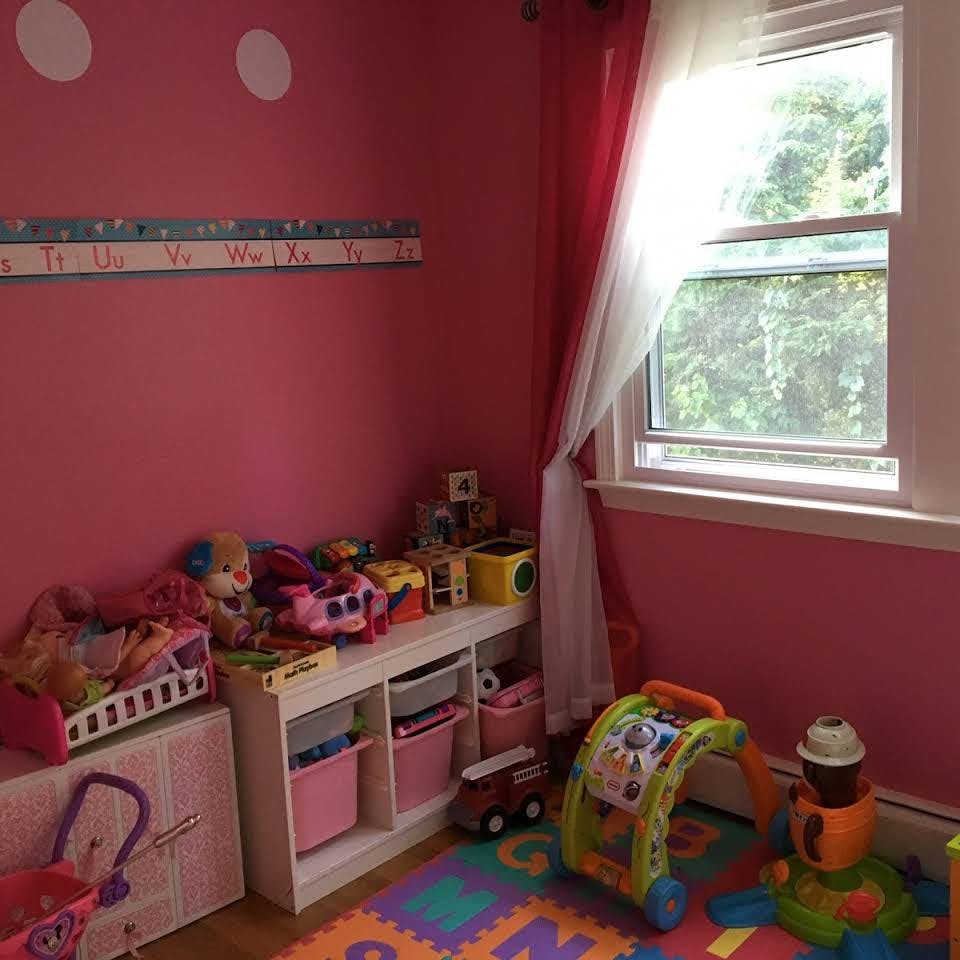 Child's room with toys, storage shelves, and a window