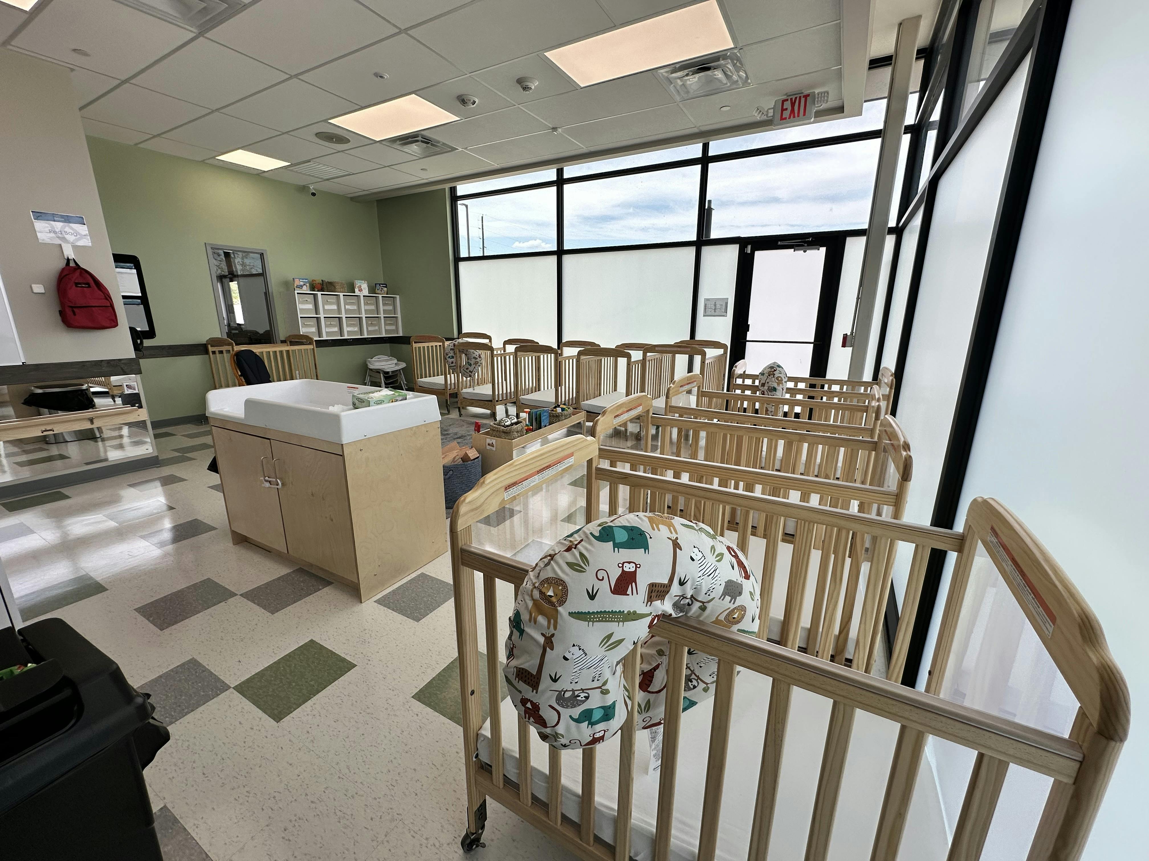 Room with multiple cribs and a changing table