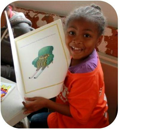 Child holding an open book with an illustration