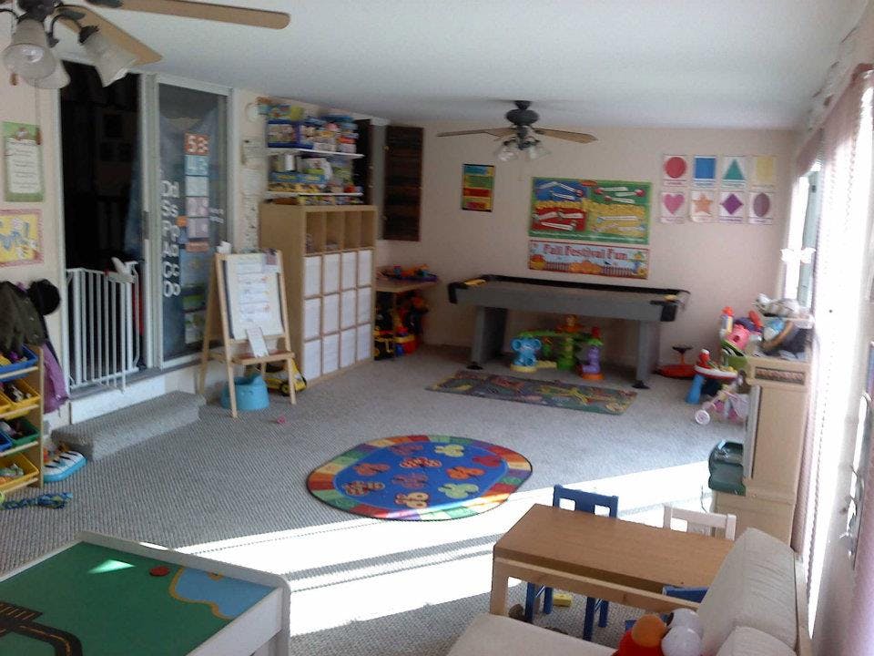 Playroom with a colorful rug, small tables, and toys