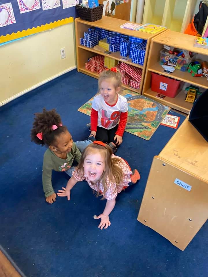 Three children on the floor in a classroom