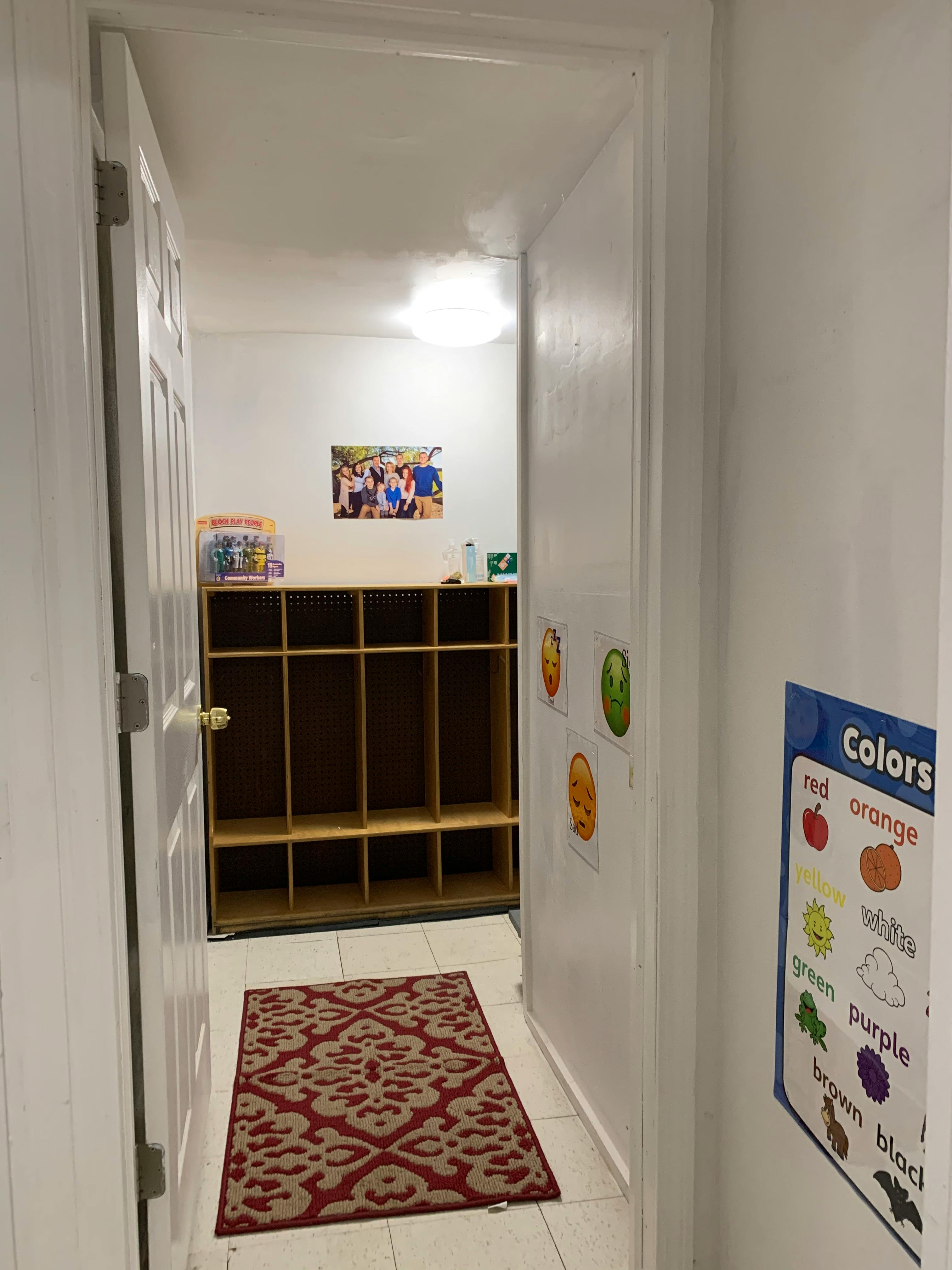 Hallway with a rug, cubbies, and a "Colors" chart on the wall